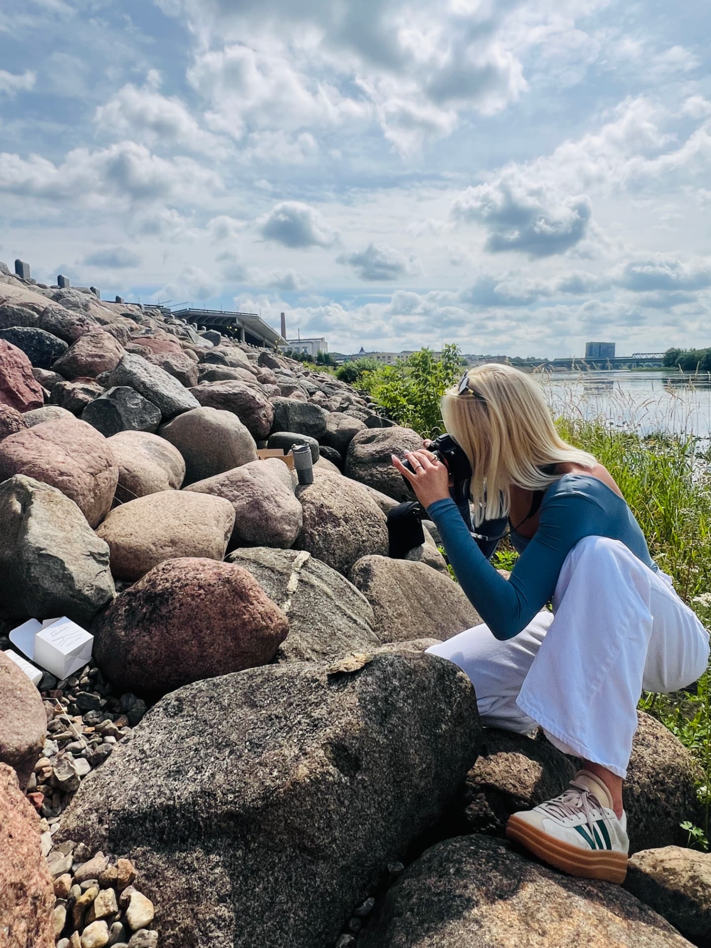 A NIDA JOURNEY candle being photographed on the riverside boulders in Kaunas